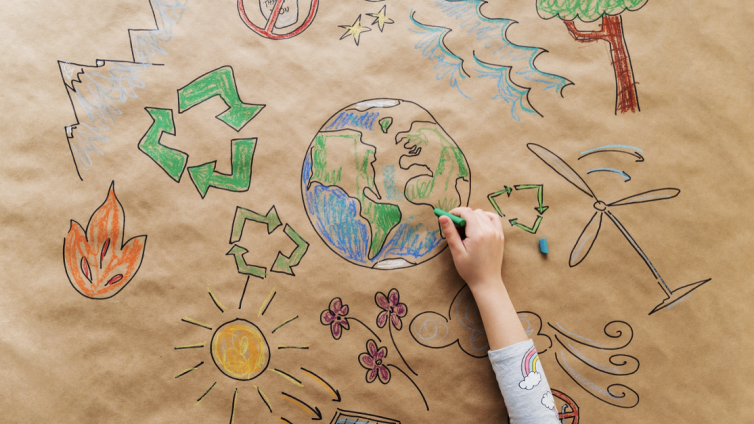 Hand drawing eco-friendly doodles of the earth, the sun, and recycling logos and on cardboard paper